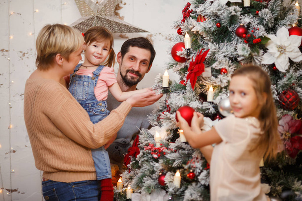 Image of happy family near decorated New Year tree - Фото, изображение