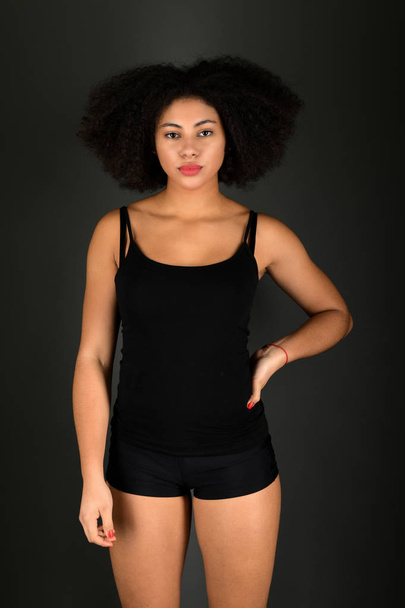 Young black woman with afro hairstyle smiling.  - 写真・画像