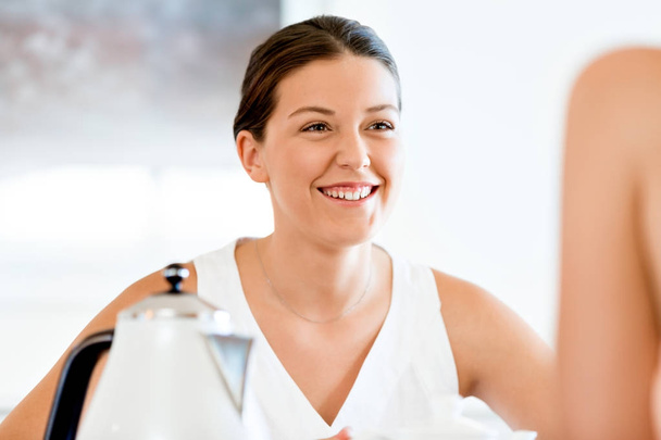 Νεαρή γυναίκα με το φίλο που κάθεται στο τραπέζι - Φωτογραφία, εικόνα