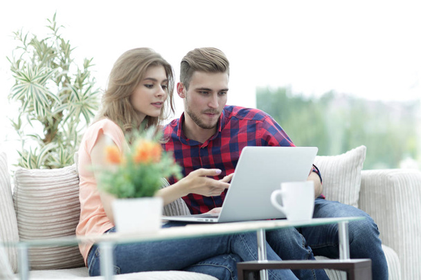 young woman showing important information to her boyfriend on the laptop screen - Fotoğraf, Görsel