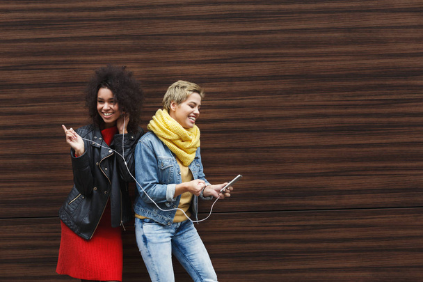 Щасливі друзі жінки слухають музику на відкритому повітрі
 - Фото, зображення
