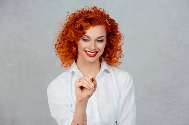 Writing. Portrait close up of happy beautiful young red head woman writing holding pen thinking looking at pencil isolated gray wall background with copy space. Positive Human face expression emotion - Fotoğraf, Görsel