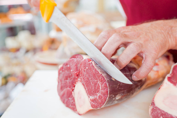 Butcher carving meat and beef - Fotó, kép