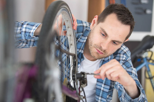 repair of a bicycle with a wrench - Foto, afbeelding