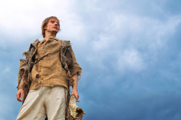 junger Mann im mittelalterlichen Bauernkostüm auf Himmelshintergrund - Foto, Bild