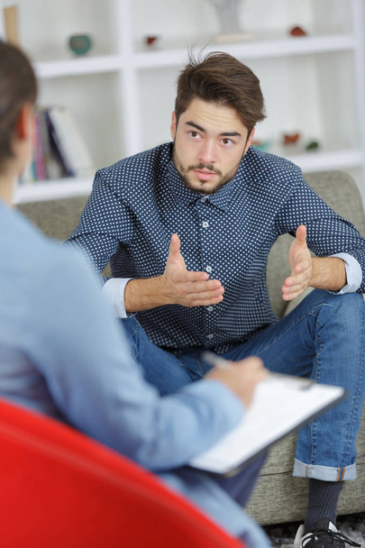 worried young man on psychotherapy with doctor - Foto, immagini