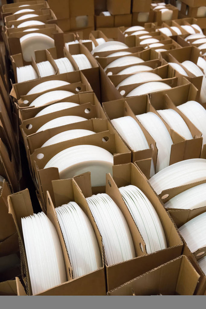 Montones de placas de porcelana blancas y redondas en cajas
. - Foto, Imagen