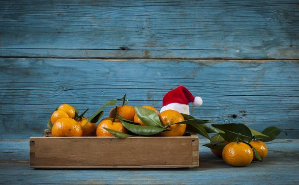 Fresh tangerines in an old box with leaves - Photo, Image