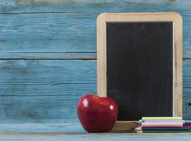 School supplies on blackboard  and empty surface. - Photo, Image
