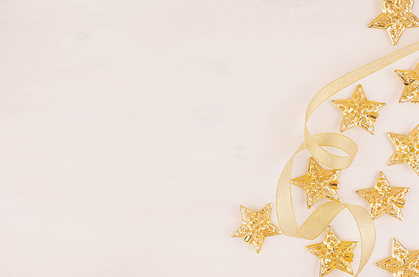 Christmas tree of gold stars, curl ribbons on soft white wood board, half. - Fotó, kép