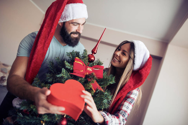 Couple échangeant des cadeaux par arbre de Noël
 - Photo, image