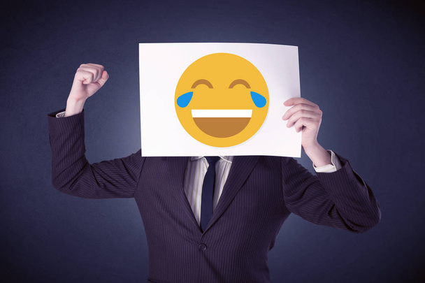 Businessman holding paper with laughing emoticon - Foto, imagen