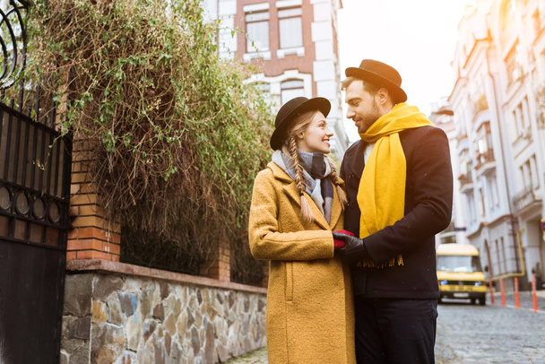 beautiful young couple in autumn outfit looking at each other - Фото, зображення