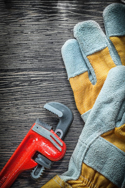 Plumbing adjustable wrench protective gloves on wooden board - 写真・画像
