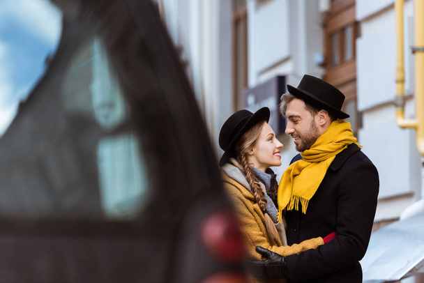 young attractive couple hugging behind car - Foto, imagen