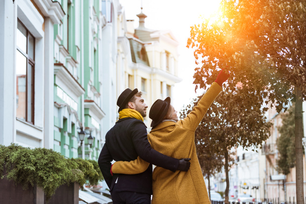 back view of young couple hugging and walking at street - Фото, зображення