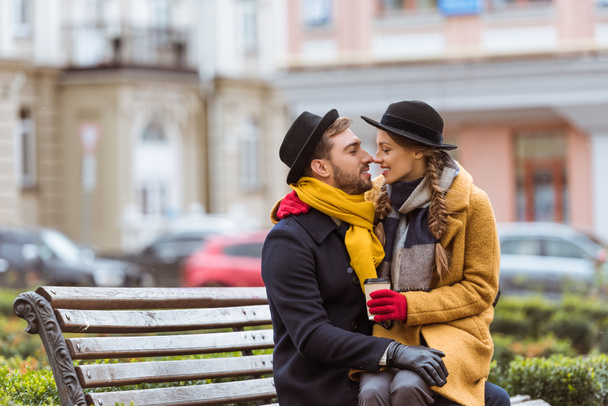 beautiful couple sitting on bench with coffee cup - Foto, Bild