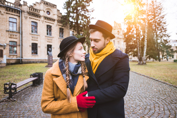 young couple in autumn outfit hugging and looking at each other - Фото, зображення