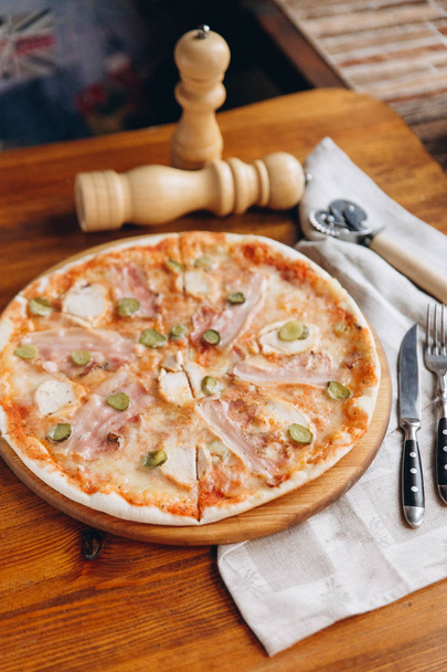 Sabrosa pizza de carne en una zanja de madera con servilleta de lino
  - Foto, imagen