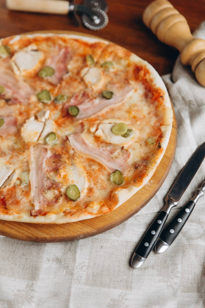 Sabrosa pizza de carne en una zanja de madera con servilleta de lino
  - Foto, imagen