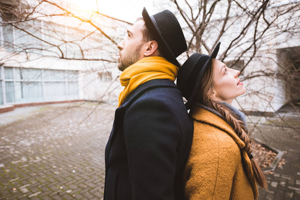 young attractive couple standing back to back infront of building - Foto, Bild