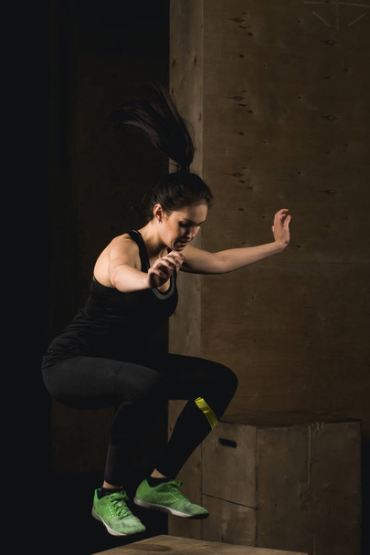 Fit woman doing box jumping at crossfit gym - Fotó, kép