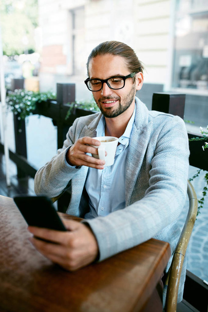 Man With Phone Drinking Coffee In Cafe - Foto, Bild