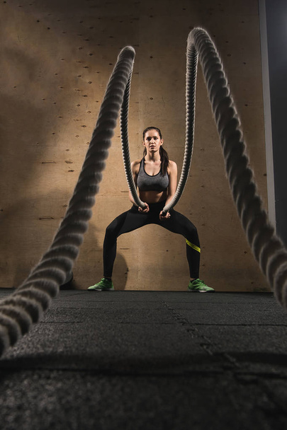 woman working out with battle ropes - Fotó, kép