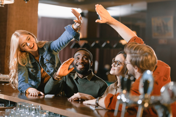 Genç arkadaşlar birbirlerine beşlik veren Bar - Fotoğraf, Görsel