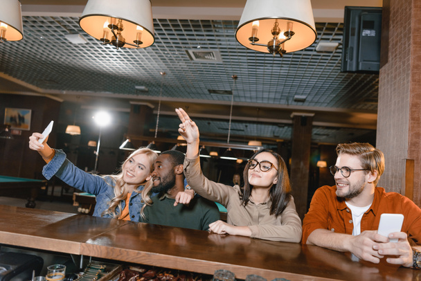 alegres jóvenes amigos tomando selfie en el bar
 - Foto, Imagen