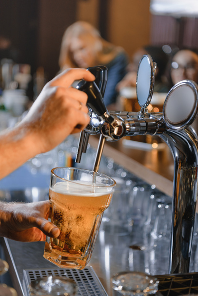 imagen recortada de barman vertiendo cerveza en vidrio en el bar
 - Foto, imagen
