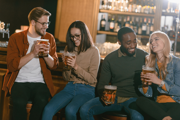 cheerful multiculture friends drinking beer together at bar   - Photo, image