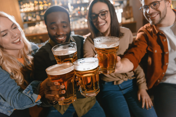 Veselá multikulturní přátel popíjí pivo společně na baru - Fotografie, Obrázek