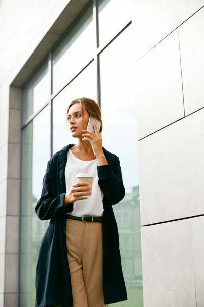 Business Woman Style. Woman Drinking Coffee And Talking On Phone - Foto, immagini