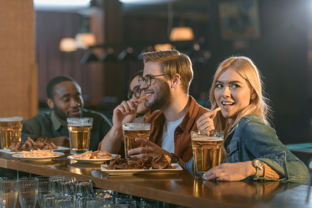 houkutteleva monikulttuurinen ystäviä syöminen ja juominen baarissa
 - Valokuva, kuva