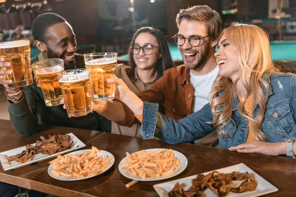 Jong multicultuur bedrijf eten en drinken bij bar - Foto, afbeelding