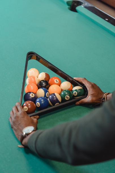 cropped image of male hands forming set of billiard balls by triangle - Photo, Image