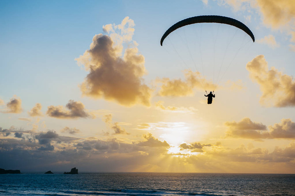 Silhouette del paracadutista che scivola sul tramonto marino
 - Foto, immagini