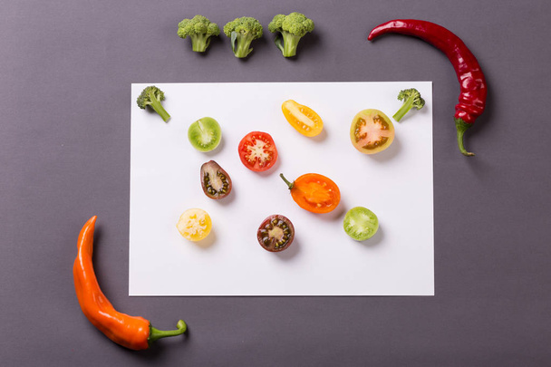 Chilli papričky s rajčaty a brokolicí na šedé a bílé pozadí - Fotografie, Obrázek