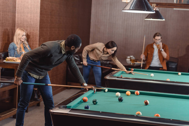 young successful multiculture friends playing in pool at bar - Photo, Image