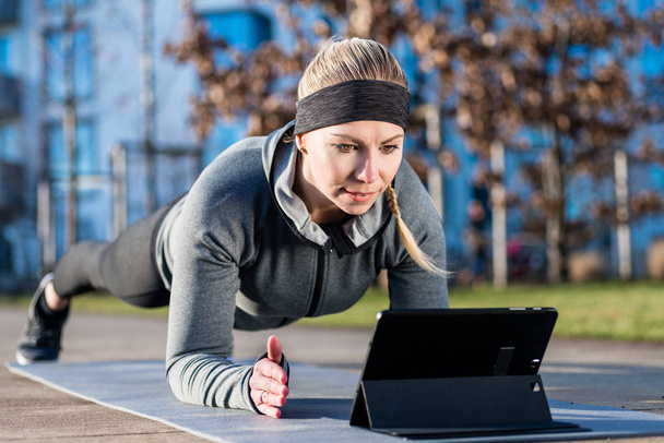 Mujer joven viendo un video motivacional mientras hace ejercicio de la p
 - Foto, imagen