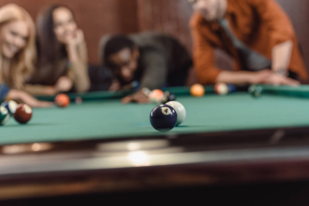 young multiethnic friends playing in pool at bar - Photo, Image