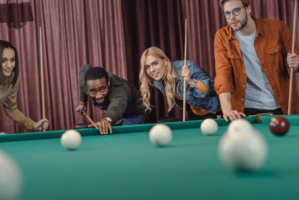 young multiethnic friends playing in pool at bar - Photo, Image