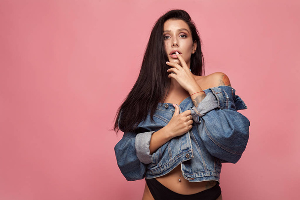 Sexy woman body in jeans jacket. The model is back. Great ass. Buttocks on pink background. - Φωτογραφία, εικόνα