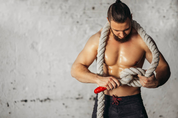 Photo of young man in sportswear knits the knot .Strength and motivation. - Zdjęcie, obraz