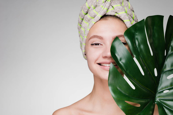 beautiful young girl doing spa procedure, smiling, holding a green leaf - Fotografie, Obrázek