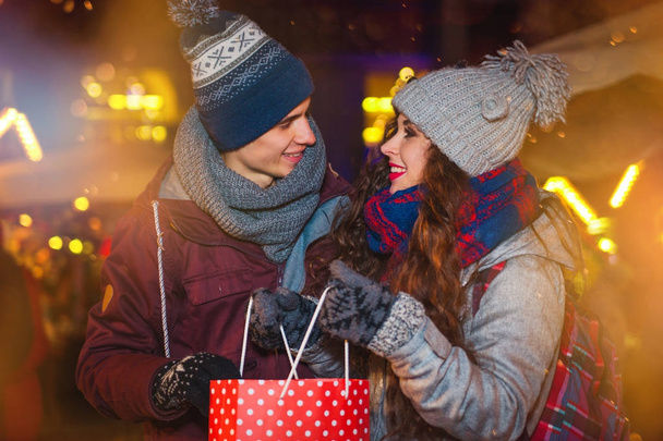Couple with shopping bag on traditional Christmas market, Holidays shopping - Фото, изображение