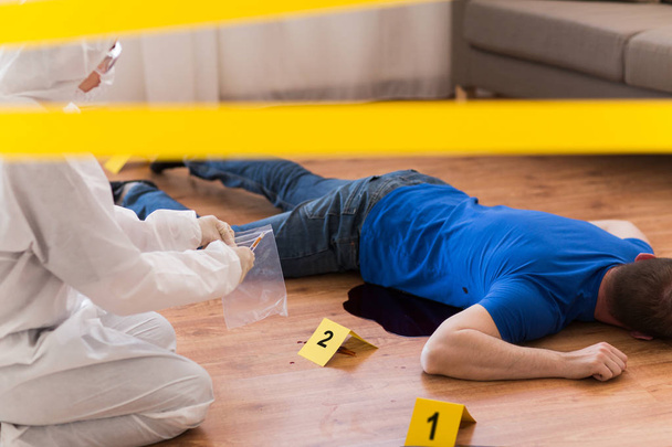 criminalist collecting evidence at crime scene - Foto, afbeelding