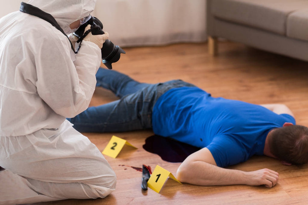 criminalist photographing dead body at crime scene - Photo, Image