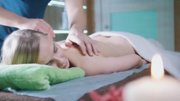 Mans hands on the back of the girl in massage parlor - Metraje, vídeo